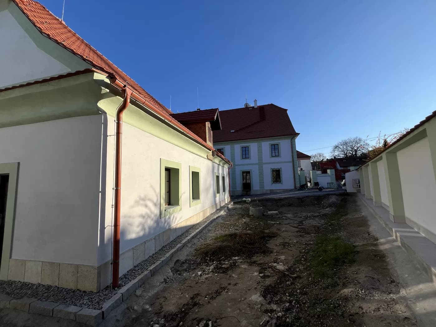 Dvůr s dlážděnou plochou a sousední budovou